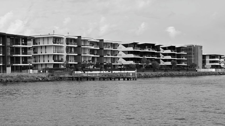 Black and white photo of modern waterfront apartments in Brisbane, Australia.
