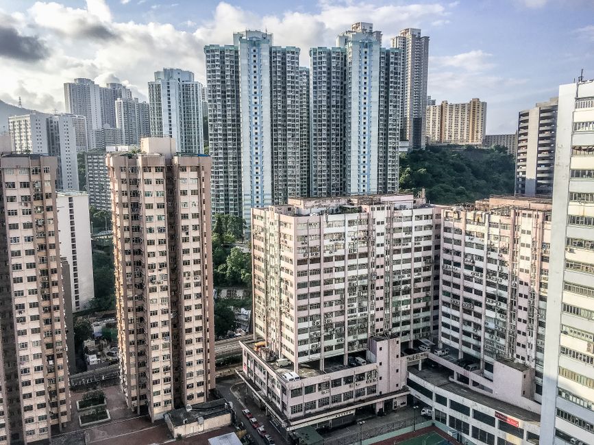 Aerial view of a dense urban cityscape featuring towering high-rise buildings in daylight.